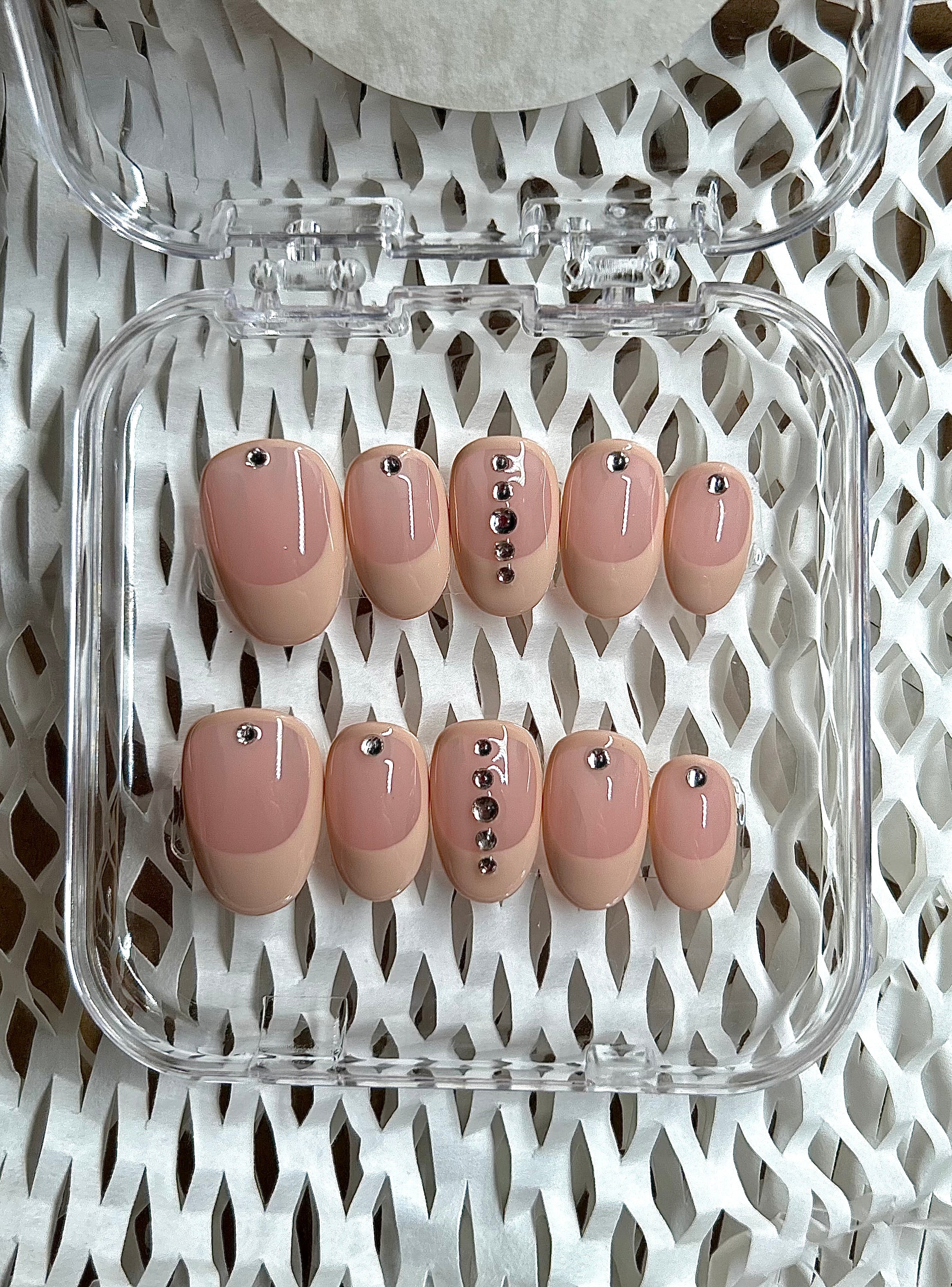 Light pink press-on nails in almond shape, offering a soft and feminine look with handpainted details.