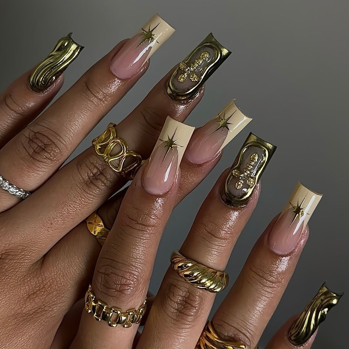 Beige chrome nails with beige gold accents and French gold tips for a sophisticated and glamorous manicure.