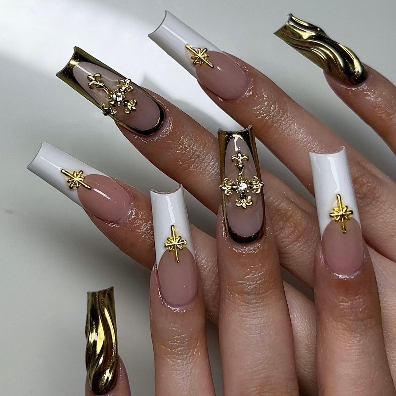 French nails with gold tips featuring elegant white and gold nail designs for a sophisticated and chic manicure.