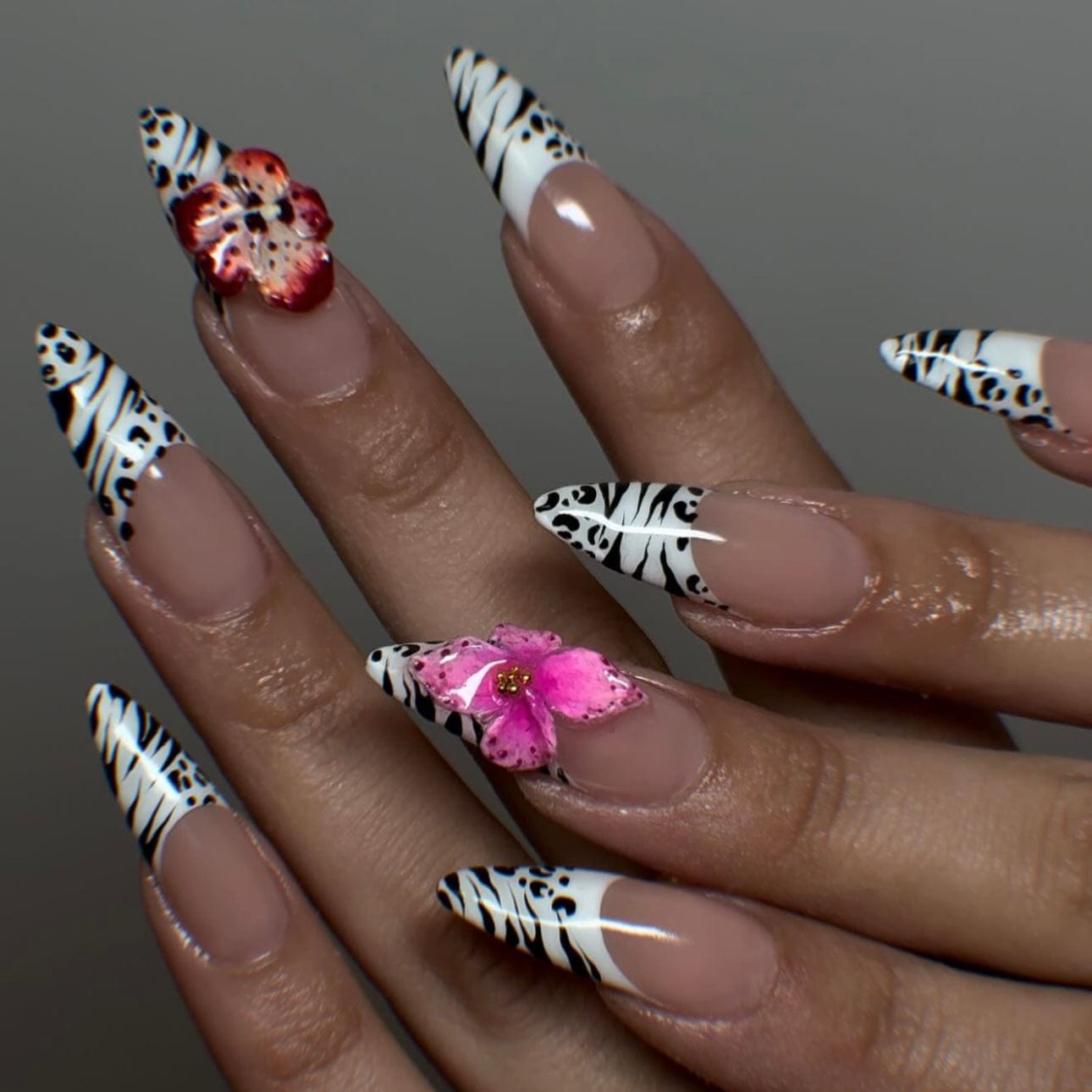 Hawaiian flower nails with a French tip, hot pink flower accents, and a pink and white ombre base for a tropical and chic summer manicure.