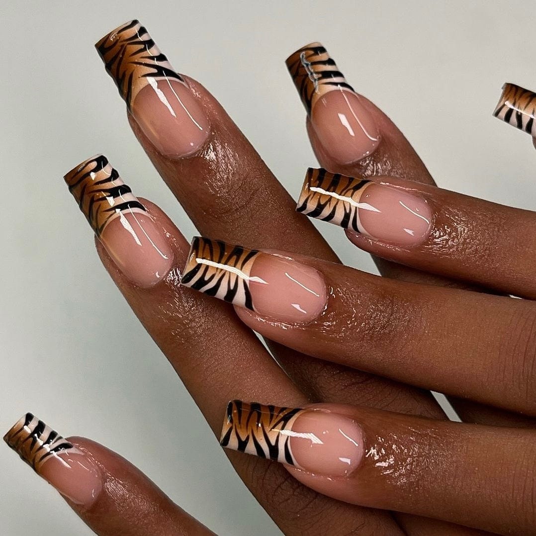 Long French tip press-on nails featuring stylish zebra accents.