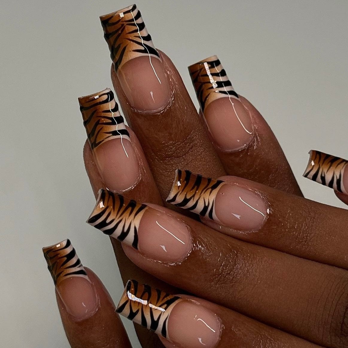 Zebra French tip nails adding a bold twist to a classic French design.